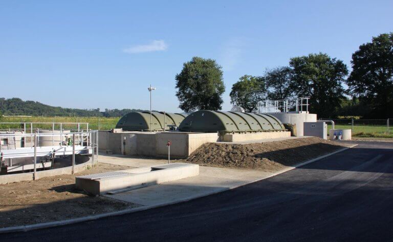 2 large green fluid tanks embedded in the ground